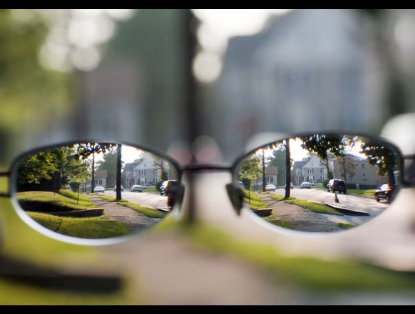 A street viewed through eyeglasses, with the surrounding scene out of focus